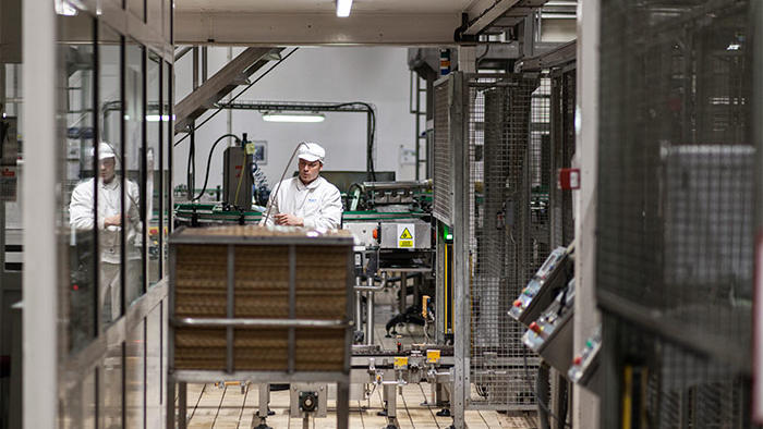 Seorang pekerja di pabrik Hero, diterangi dengan pencahayaan LED industri makanan yang hemat energi dari Philips