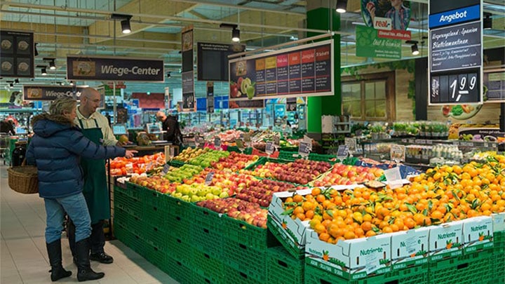 Pelanggan melihat buah di Real yang diterangi menggunakan pencahayaan supermarket Philips