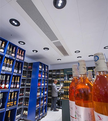 Kontras dan kilauan yang luar biasa di bagian minuman anggur di supermarket Irma oleh produk Philips lighting 