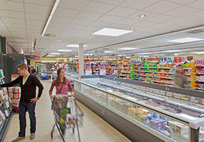 Pasangan berjalan di lorong supermarket yang diterangi dengan lampu hemat energi Philips 