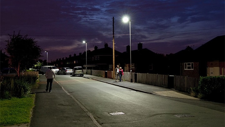 People are walking in a street lit by Philips