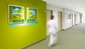 Nurse is walking in a green hospital’s corridor 
