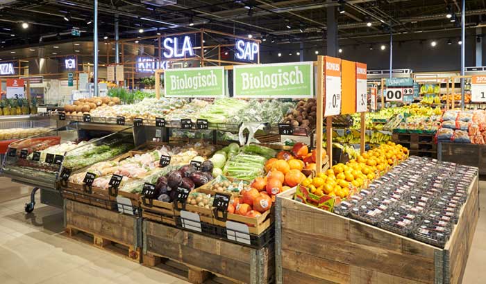 A well-stocked fresh fruit and vegetables section of an Albert Heijn supermarket.