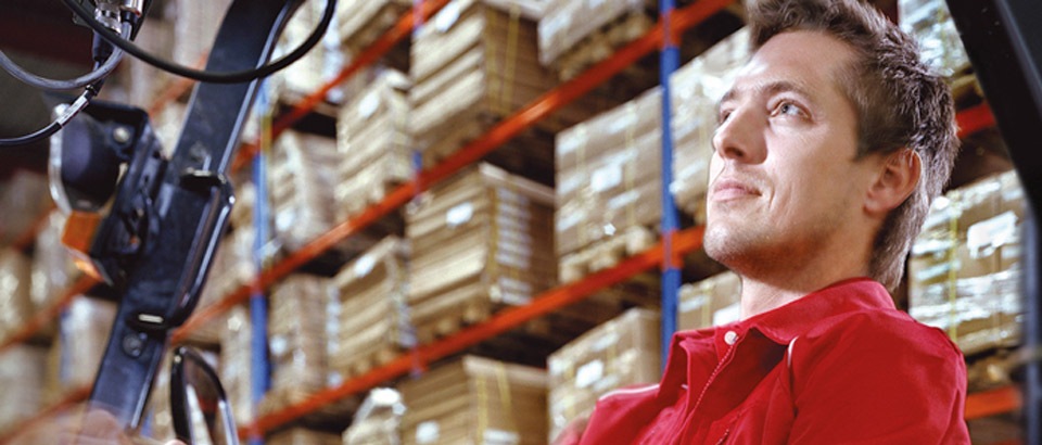 Man drives forklift with palettes in warehouse | Industry Lighting