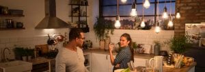 "Dapur modern dengan lampu gantung LED bergaya vintage yang menerangi dua wanita saat menikmati makan malam, menciptakan suasana hangat dan menyenangkan."